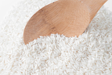 Rise with a wooden spoon on white background