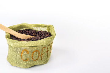 wooden spoon in a bag full of coffee beans