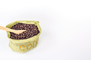 wooden spoon in a bag full of coffee beans