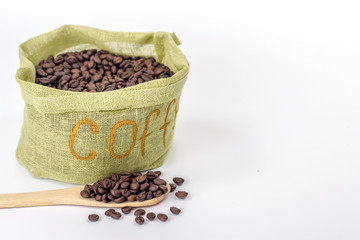 Fototapeta na wymiar wooden spoon on a background of green bag full of coffee beans