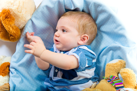 Cute baby inside basket playing with stuffed animals