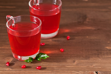 glass of pomegranate juice with fresh fruits on wooden table