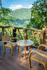 Obraz premium Wooden table and chairs in the cafe with a wonderful mountain vi