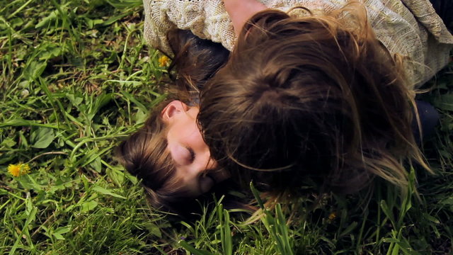 European, white-skinned children fight on green grass.