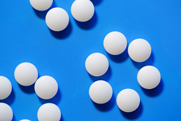 pills. White medical pills on blue background