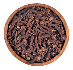 Dried clove in a wooden bowl on a white