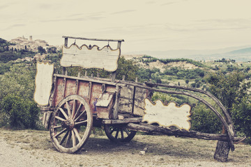 Obraz premium Old wooden cart against vineyards, Tuscany, Italy. 