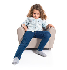 Blonde cute girl sitting on little armchair