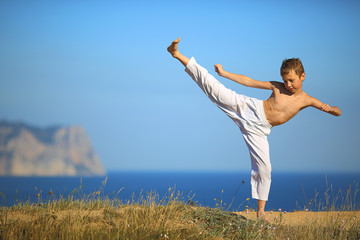 boy karate on the coast - Powered by Adobe