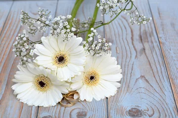 Fototapeten Witte gerbera's met gipskruid en trouwringen © trinetuzun