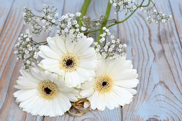 Foto auf Leinwand Weiße Gerberas mit Schleierkraut und Eheringen © trinetuzun