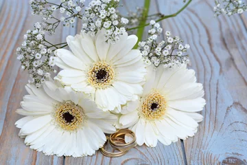 Foto auf Leinwand Weiße Gerberas mit Schleierkraut und Eheringen © trinetuzun