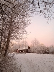 маленький домик в зимнем лесу на закате