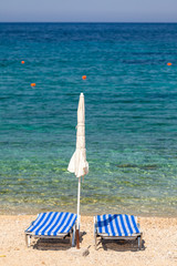 Sun beds and umbrellas on the beach of Mediterranean sea (Crete,