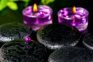 spa concept of zen basalt stones with bead, drops, lilac candles