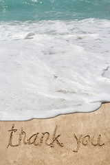 Conceptual thank you text in sand and water