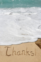 Conceptual thank you text in sand and water