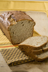 Fresh loaf of white home made bread on table cloth.