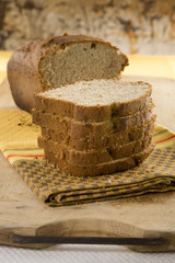 Fresh loaf of white home made bread on table cloth.
