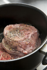 Raw meat with flavoring and spice in a pot, ready to be cooked