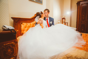Wedding shot of bride and groom lying in a stylish bed