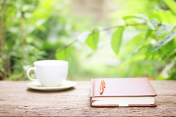 Notebook  and coffee on wooden table