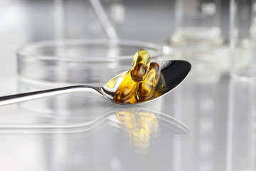 spoon vitamins pills omega 3 supplements with petri dish