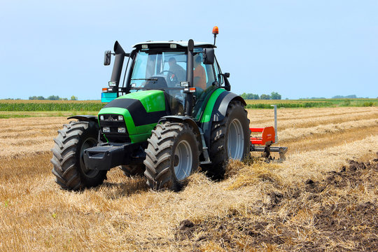 Fototapeta Tractor on the farmland