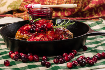 Two cranberry glazed chicken breasts in pan