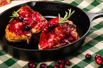 Two cranberry glazed chicken breasts in skillet