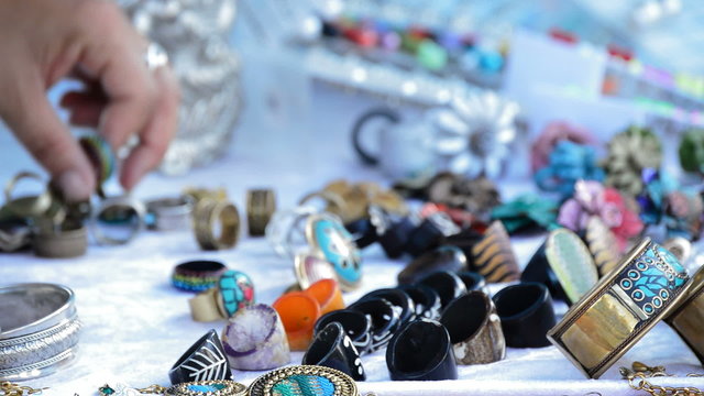 Putting rings and jewelry on a street stall selling crafts