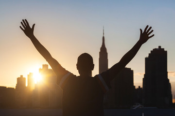 Successful Man with New York Skyline on Background at Sunset