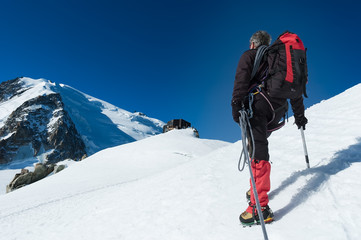 Fototapeta na wymiar Mountaineer walking on the glacier during the climb of Mont Blan