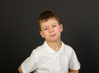 grimacing boy portrait on black