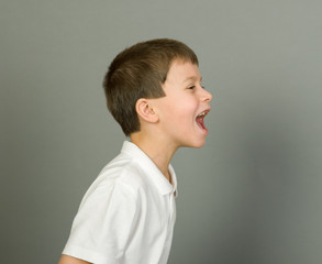 grimacing boy portrait on grey