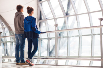 couple holding hands and waiting at airport terminal