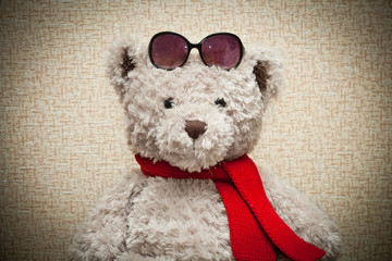 Teddy bear in a red scarf and sunglasses