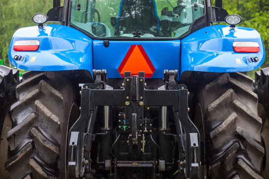 Huge rear wheels of the blue new tractor