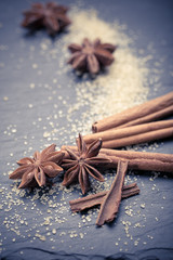 Star anise with cinnamon sticks over black stones background 