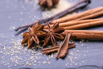 Star anise with cinnamon sticks over black stones background 