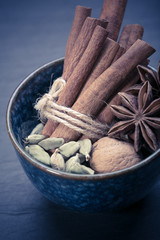Bunch of cinnamon sticks, anise stars, cardamom in the bowl 