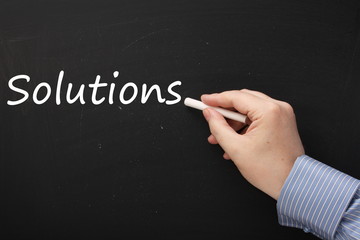 Writing the word Solutions on a Blackboard
