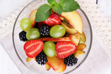 fresh tasty fruit salad on wooden table