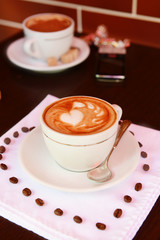 Cup of coffee with cute drawing in cafe