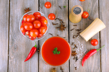 Tomato juice in goblet and fresh vegetables on wooden