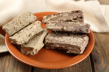 Two kinds of sunflower halva on plate, on wooden background