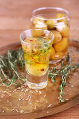Green olives in oil with spices and rosemary in glass jars