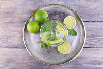 Obraz na płótnie Canvas Lemonade in glass on tray on wooden background