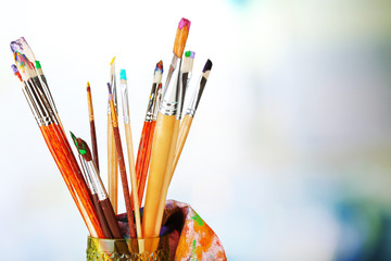 Paint brushes with paints on bright background