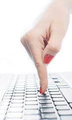 Female finger typing button on laptop keyboard,selective focus